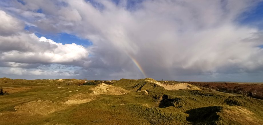 Das Bild zeigt die Landschaft im Inselosten mit einem Regenbogen